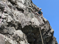 Chuck-at-Llanberis-Pass-on-a-crux-move-involving-en-route-guidebook-reading_photo-by-Kat